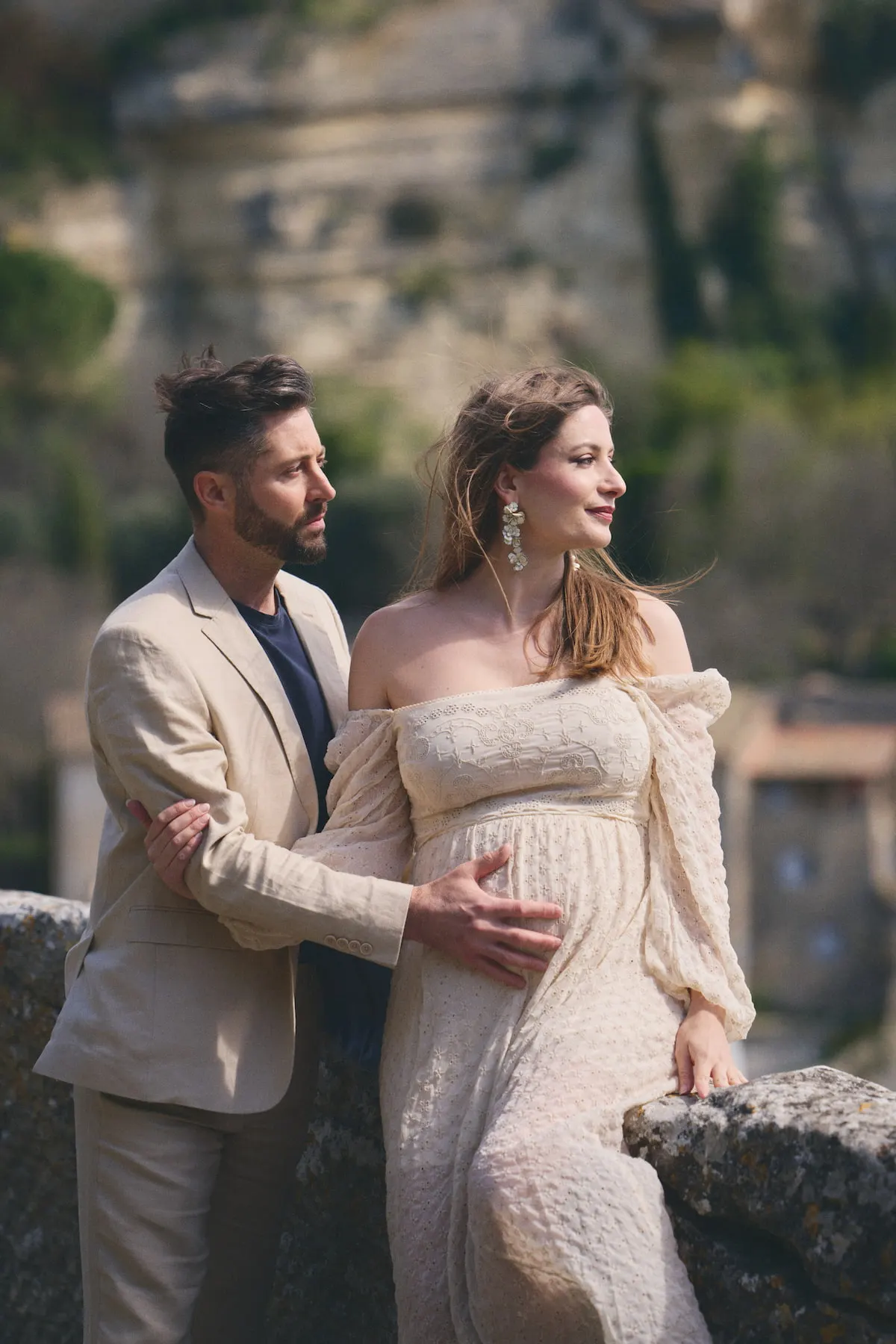 Séance photo grossesse en couple sur une terrasse de pierre face au village de Gordes, Luberon
