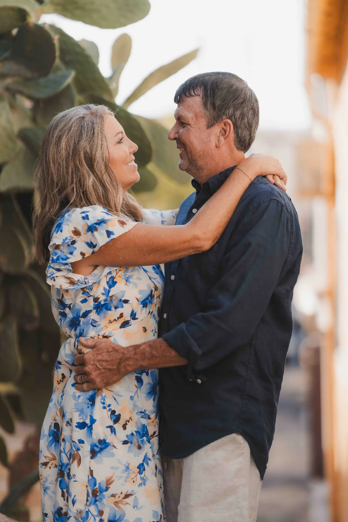 Couple embracing and laughing in a sunlit Marseille alley during their private vacation photo session