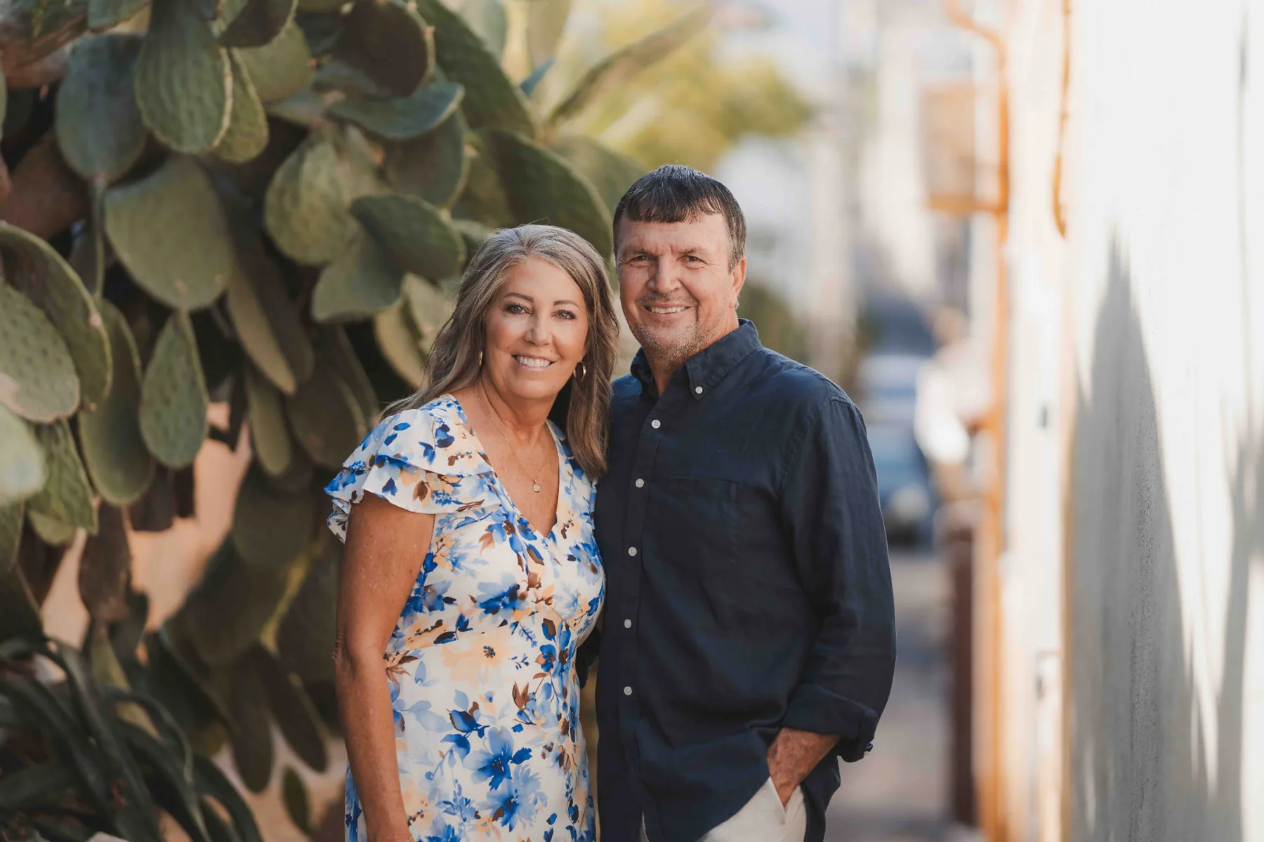 Smiling couple posing beside a prickly pear cactus in a narrow Malmousque alley — Marseille photo session