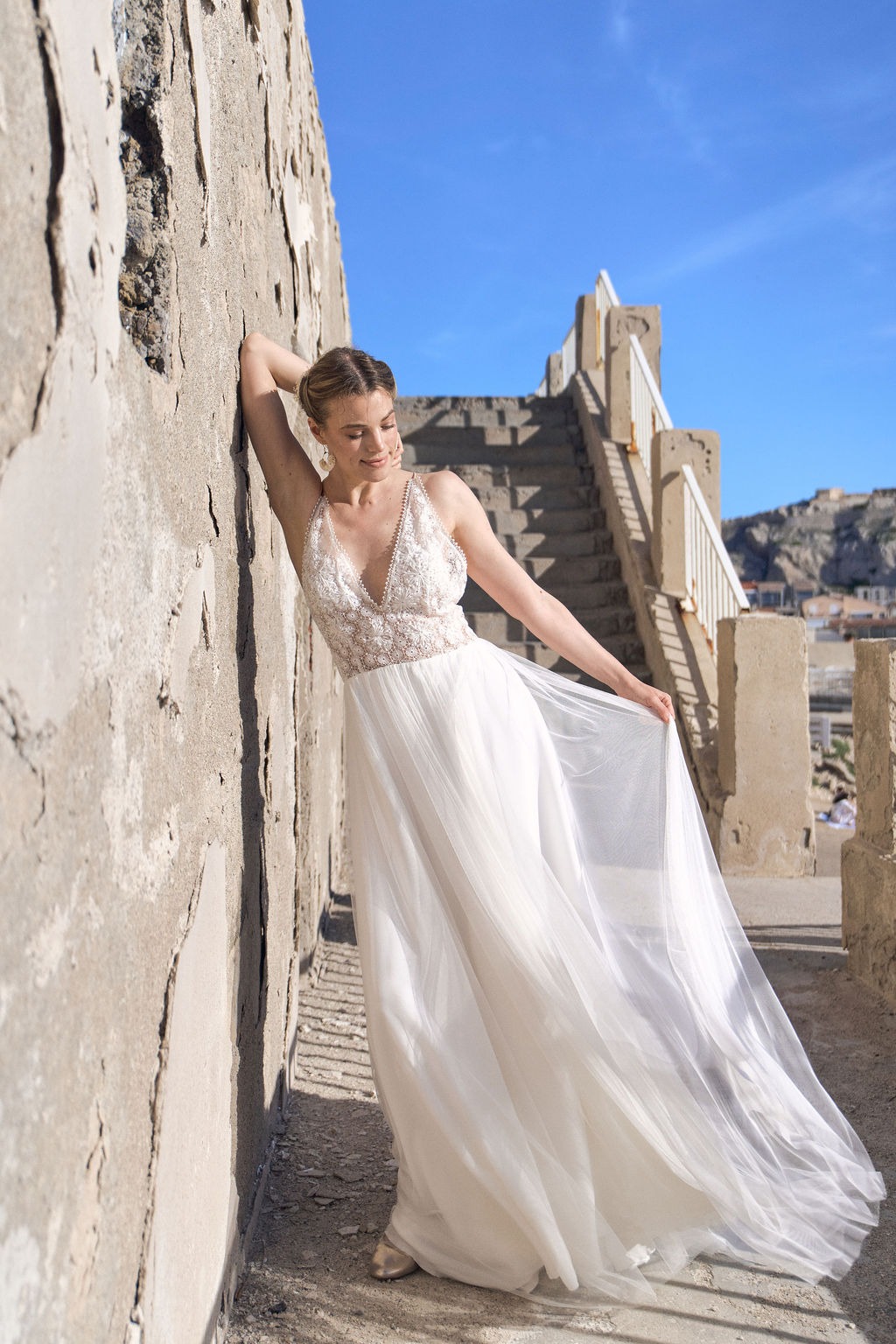 Tulle wedding dress by Lambert Création with flowing cape on the Mediterranean coastline, South of France